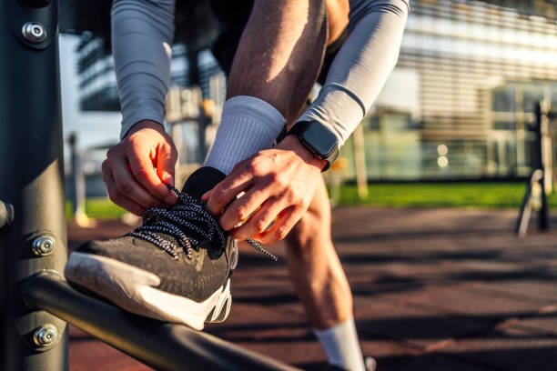 Male runner tying his shoelace and preparing for a run